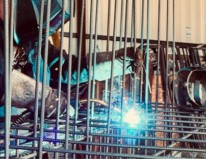 A welder joining steel reinforcement bars, highlighting ARGE Baustahl’s precision work supported by automated data extraction and smarter workflows that reduce errors and speed up production.