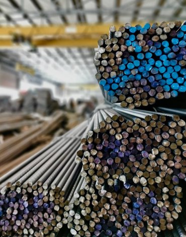 Neatly stacked steel bars with colored ends, representing ARGE Baustahl’s shift from manual data entry to automated steel-list creation, resulting in faster, more accurate production.