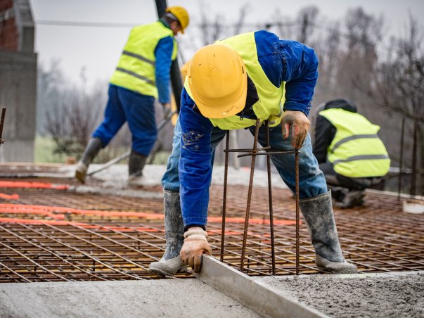 Construction worker smoothing out wet concrete