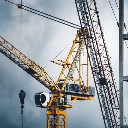 Yellow crane against grey sky, indicating a case study about construction