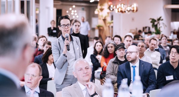 Person holding a microphone during a Q&A session, engaging with an audience where Sclable participated in the discussion