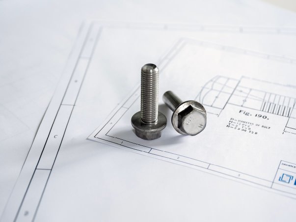 Metal bolts lying on top of technical drawing