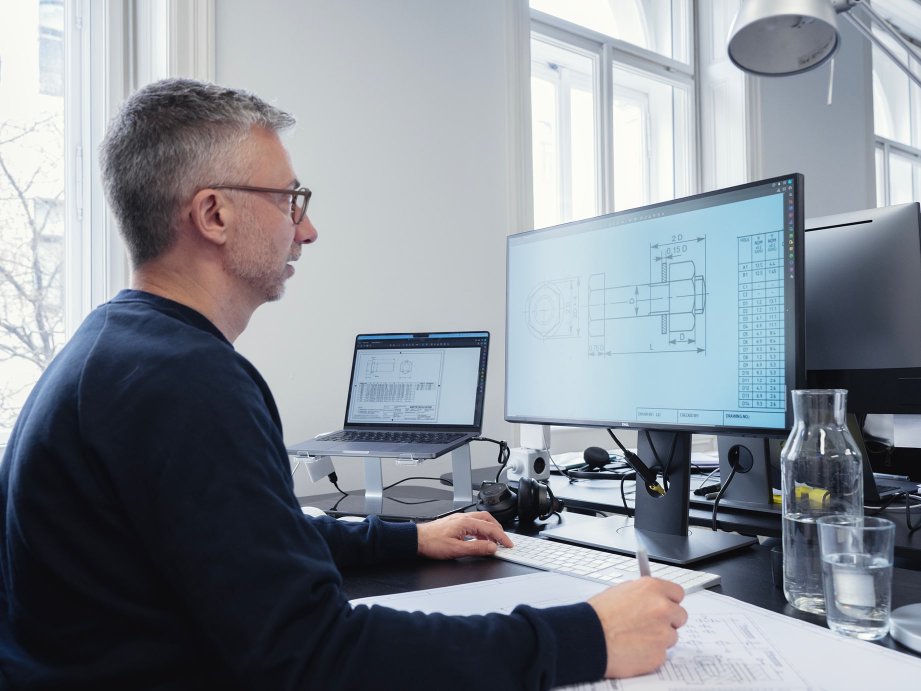 Male engineer interpreting a technical drawing on his computer screen