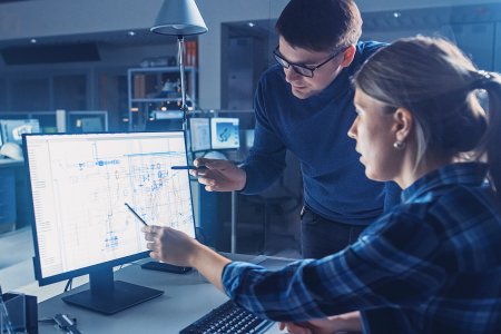 Engineers reviewing digital production schematics on a screen, representing data-driven workflow optimisation at Nedschroef.