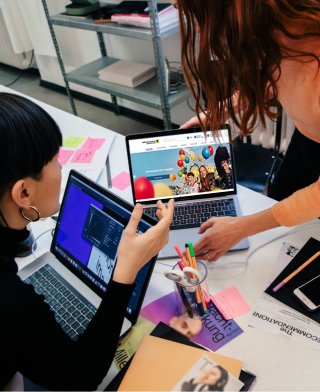 Nahaufnahme eines Design Thinking-Workshops mit handgezeichneten Diagrammen, bunten Haftnotizen und Kreativmaterialien zur Analyse von Anforderungen und Systemstrukturen.