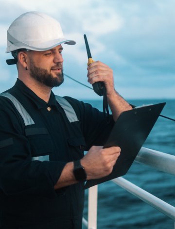 Auditor im Schiffsverkehr prüft CO₂-Emissionen mit Funkgerät und Klemmbrett – digitale Auditierungsprozesse von Swiss Climate umgesetzt mit sclable Workflow Intelligence.