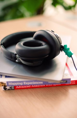 Pair of headphones placed on top of colorful books