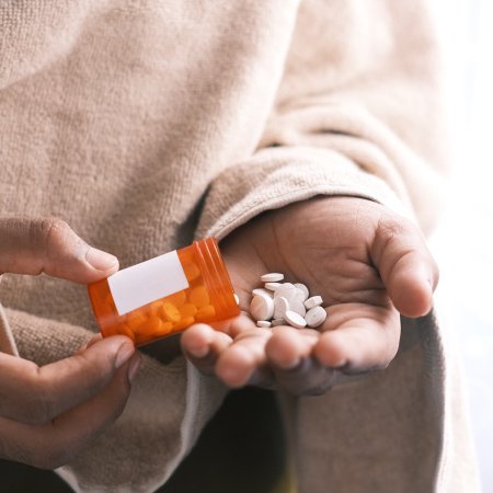 Woman's hands dosing pills from a bottle for medication management